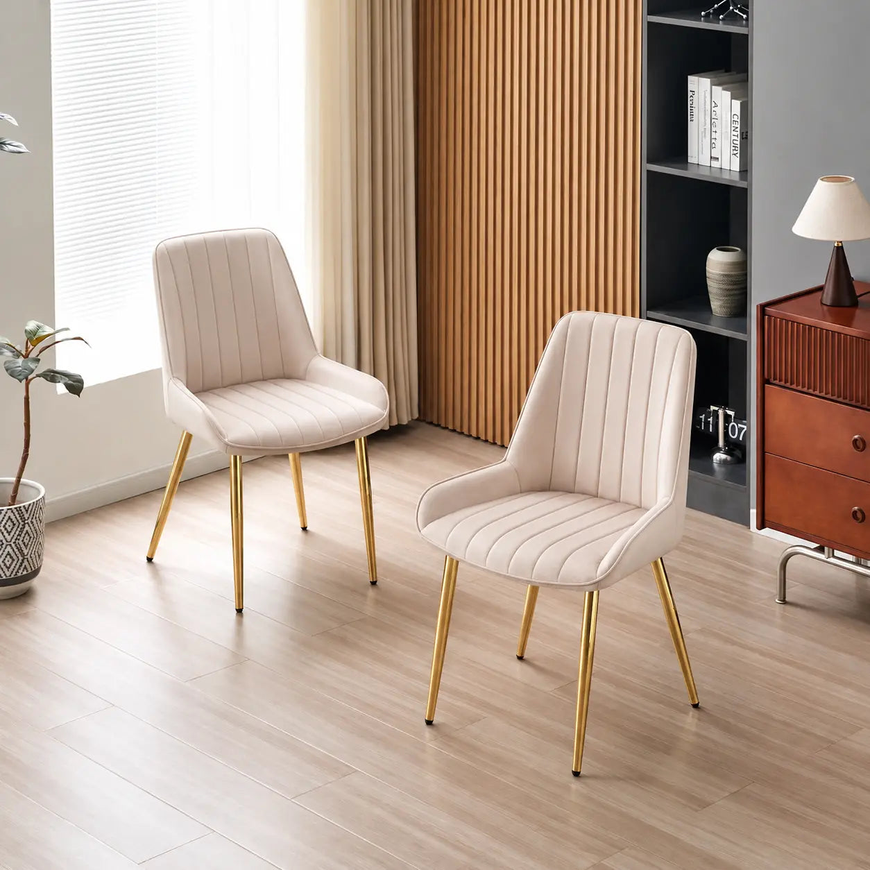 Deux chaises en velours beige avec des pieds dorés, au design élégant et moderne, ajoutent une touche de sophistication à.