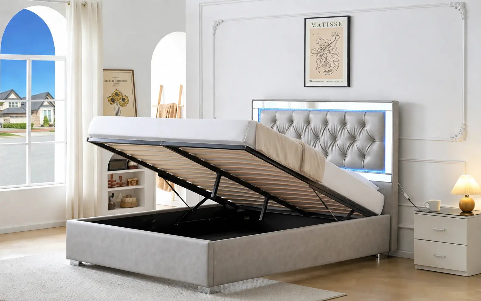 Un lit gris en tissu avec un cadre rembourré, doté dun mécanisme de levage pratique.