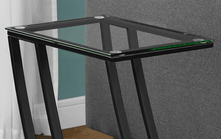 Table dappoint en métal noir avec un plateau en verre transparent, au design moderne et élégant.