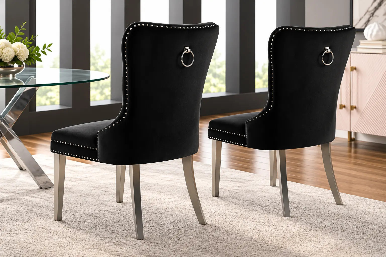 Deux chaises en velours noir, au design élégant, avec un cadre en chrome poli et un anneau décoratif à l’arrière.