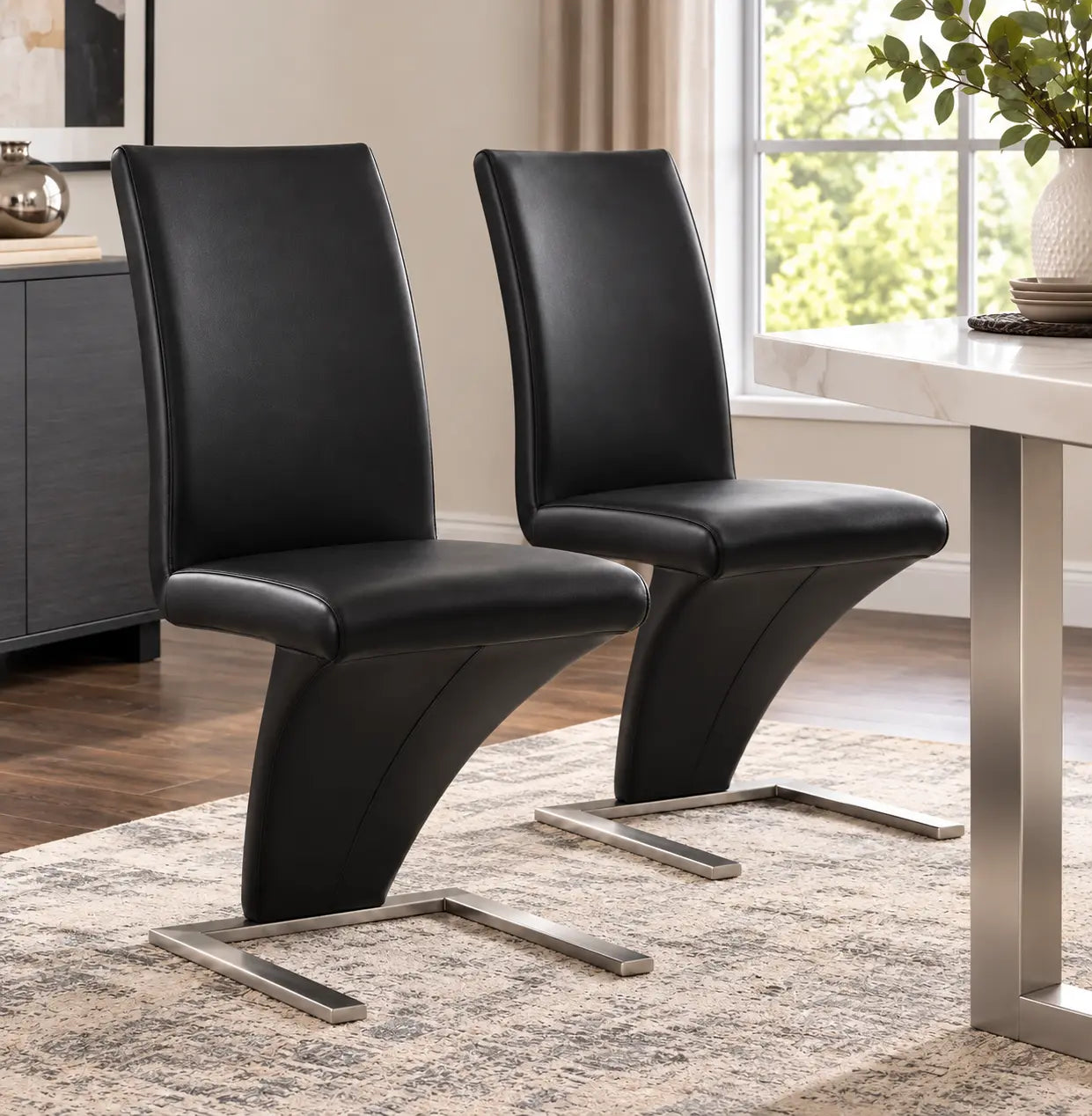 Deux chaises noires au design Z en simili cuir, avec des pieds en chrome, apportent une touche moderne à votre.