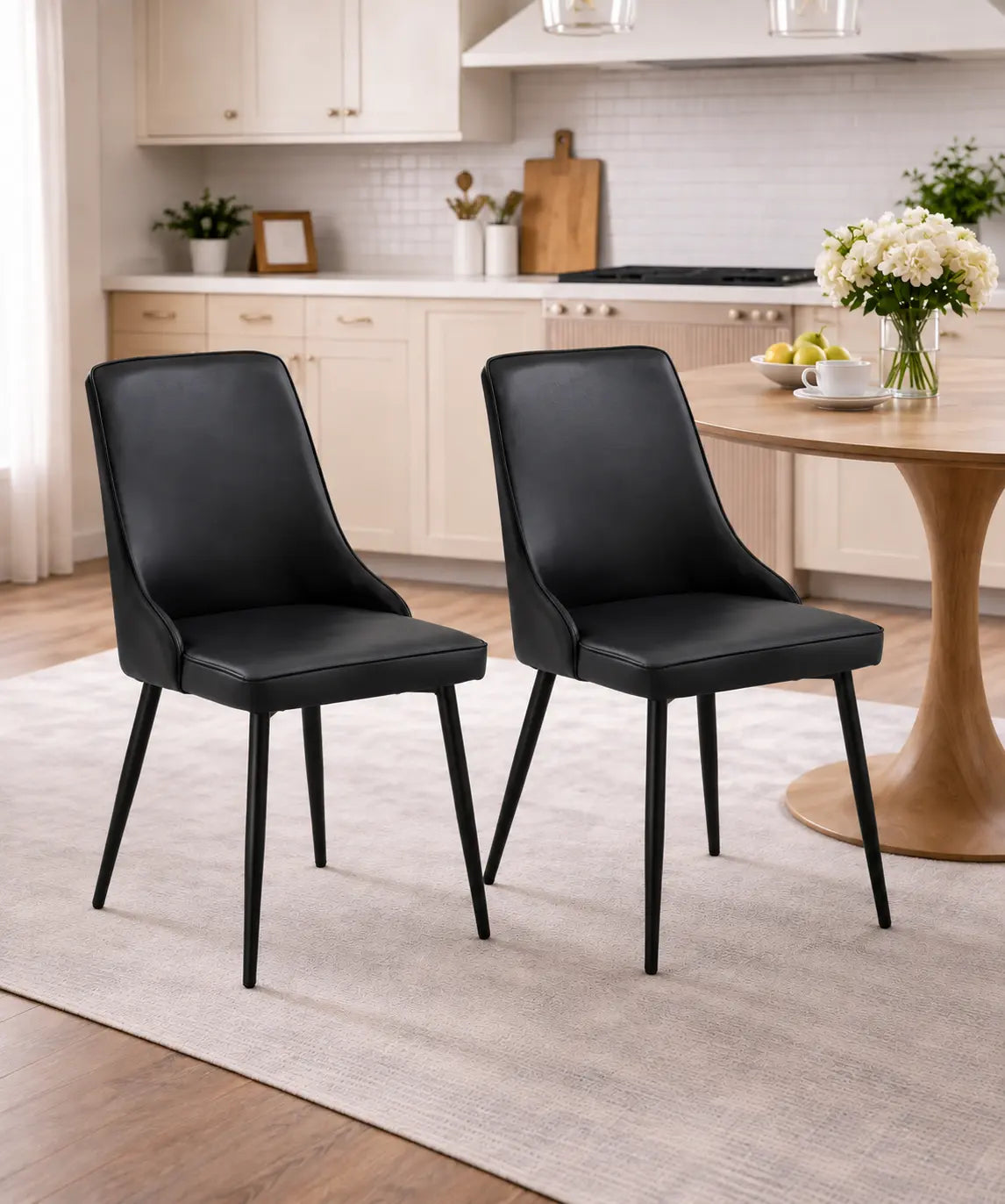 Deux chaises noires au design moderne sont placées autour dune table en bois clair dans une cuisine lumineuse.